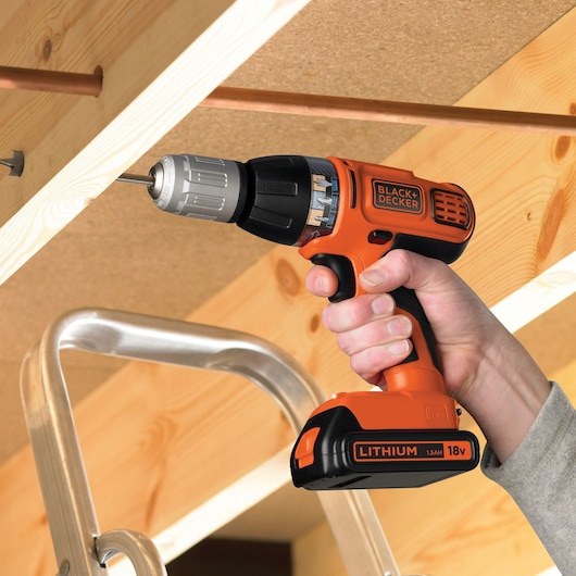 BLACKDECKER ASL188KB cordless drill in use on wood, orange and black, 18V Lithium battery visible.