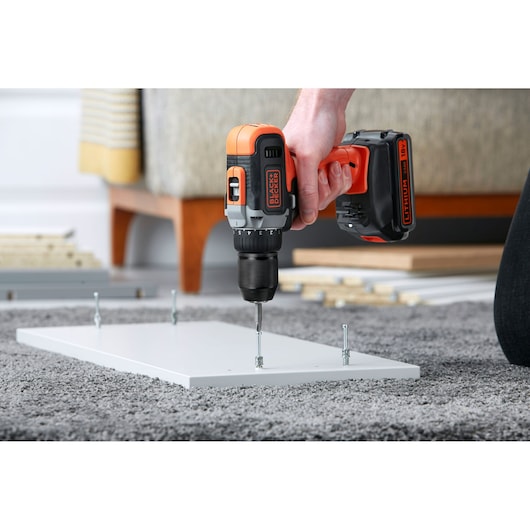 BLACKDECKER BCD002ME2K cordless drill being used to assemble white panel on carpeted floor