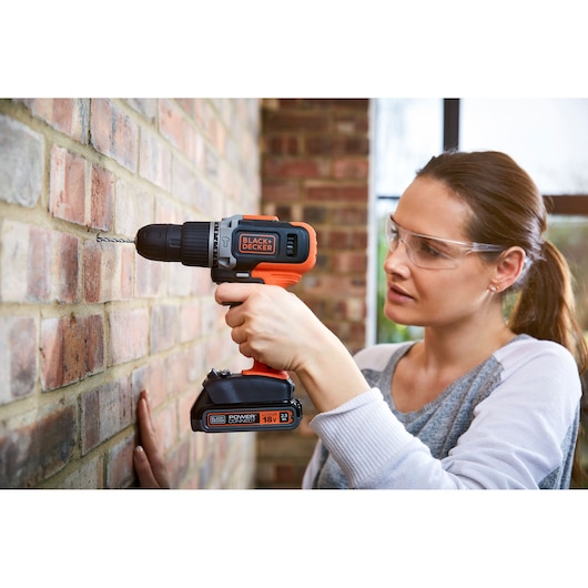 Photo of BLACKDECKER BCD003ME2K cordless drill used to drill into a brick wall.