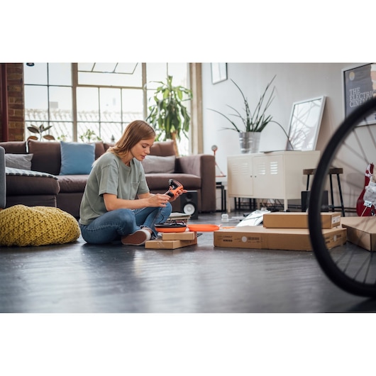 BLACKDECKER BCF611CK cordless screwdriver used for assembly in a modern living room setting.