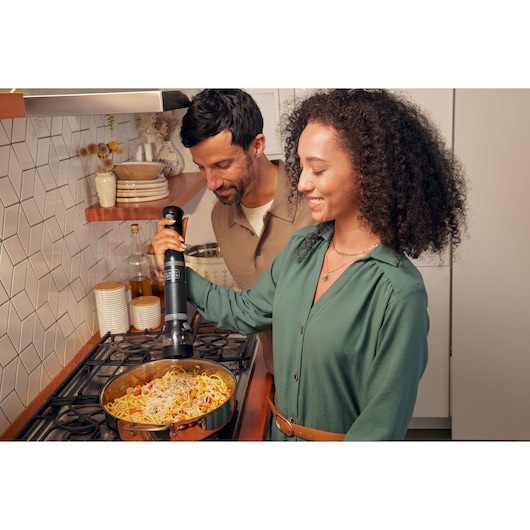 Photo of BLACKDECKER BCKM1012KB electric kitchen tool used over pasta in a pan on a stove.