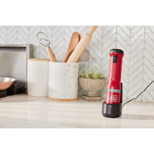 BLACKDECKER BCKM1012KR red cordless kitchen mixer upright on countertop with charging base.