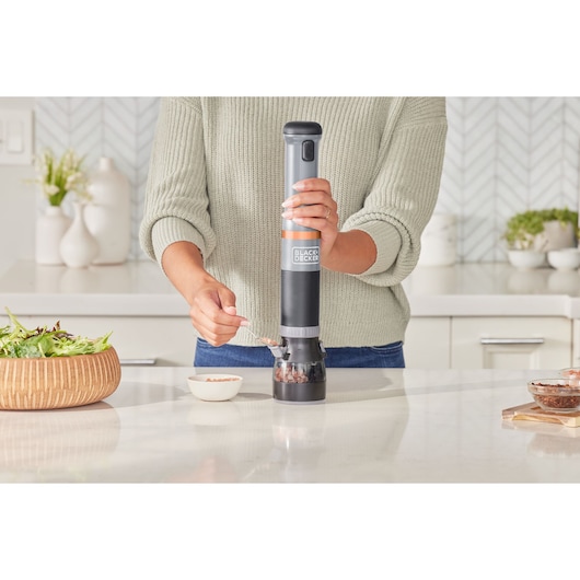 BLACKDECKER electric spice grinder BCKM1016KSG in use on a kitchen counter, grinding spices into a bowl.