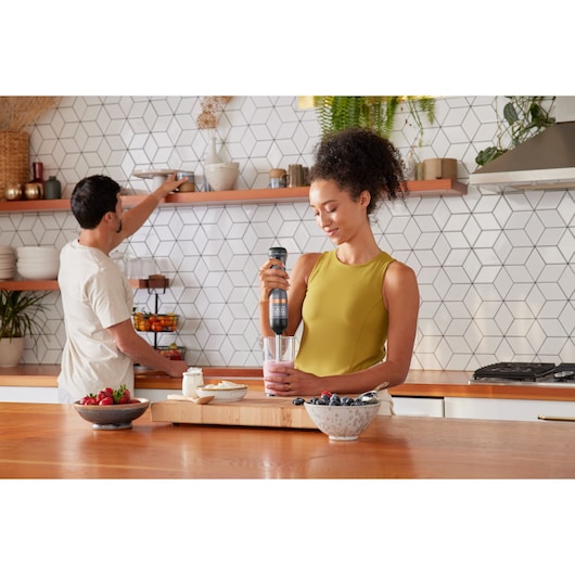 BLACKDECKER BCKM1016KSG hand blender in use for smoothie preparation in modern kitchen, fruits on counter.