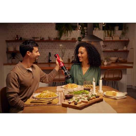 Photo of BLACKDECKER BCKM1016KSR electric pepper grinder being used at a dinner table with pasta and candles.