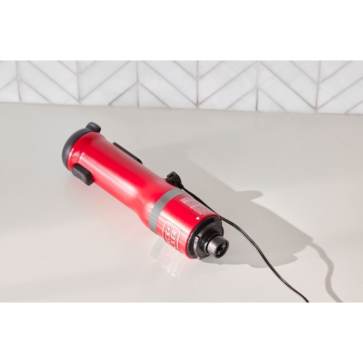 BLACKDECKER BCKM1016KSR red handheld multi-tool with black accents and attached cord on countertop.