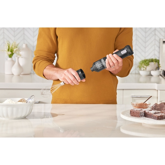BLACKDECKER BCKM101WHFF hand mixer being assembled in kitchen, whisk attachment visible.
