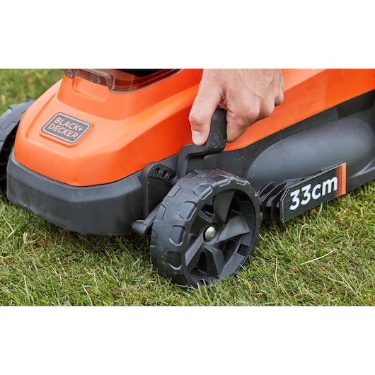 BLACKDECKER BCMW33184L2 lawn mower side view showing 33cm wheel adjustment on grass