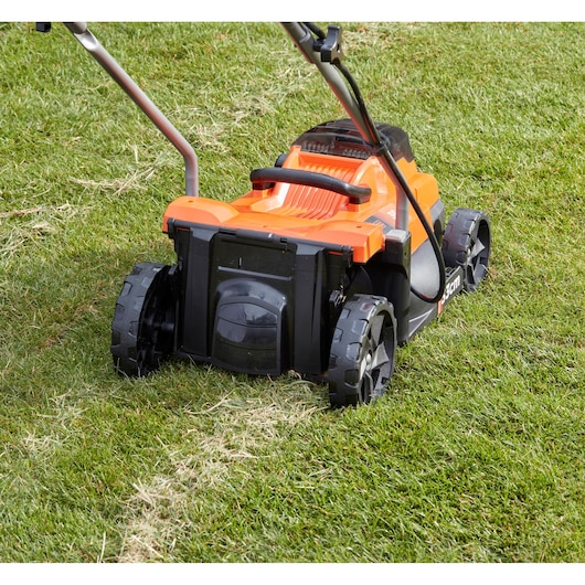 BLACKDECKER BCMW3336L2 lawn mower rear view on grass, orange and black exterior, photography.