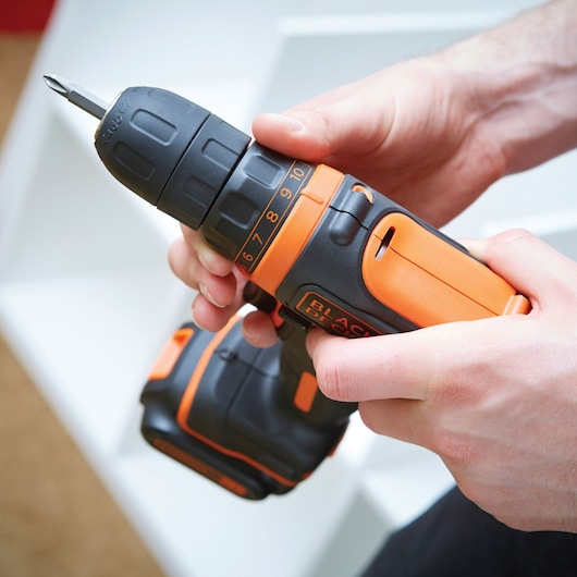 BLACKDECKER BDCDD12K cordless drill with orange and black design held in hand, side angle.