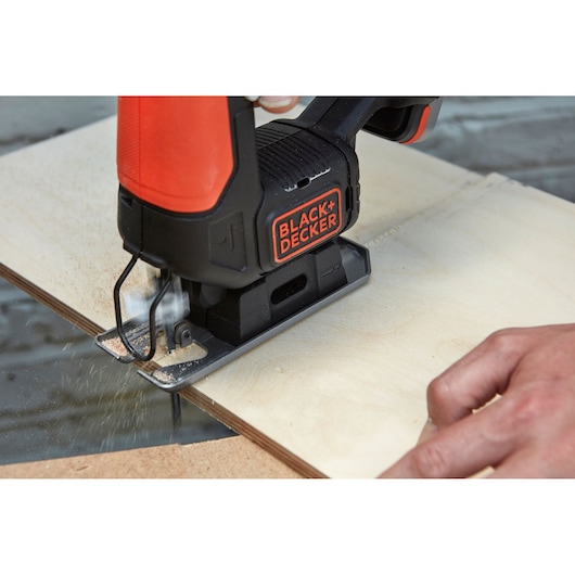 BLACKDECKER BDCJS12S1 jigsaw cutting plywood, close-up of tool in use.