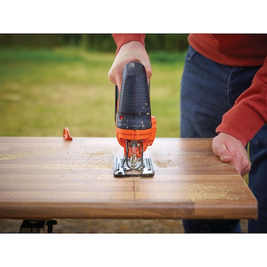 BLACKDECKER BDCJS18M1 jigsaw cutting wood outdoors, close-up of tool and straight cut.
