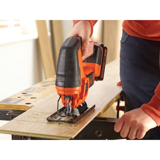 BLACKDECKER BDCJS18N cordless jigsaw cutting wood, close-up showing tool in use.