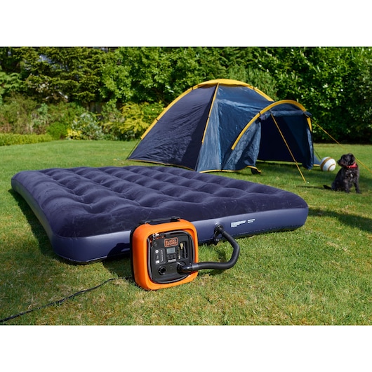 Photo of BLACKDECKER BDCOM400 portable air compressor inflating air mattress outdoors near tent.