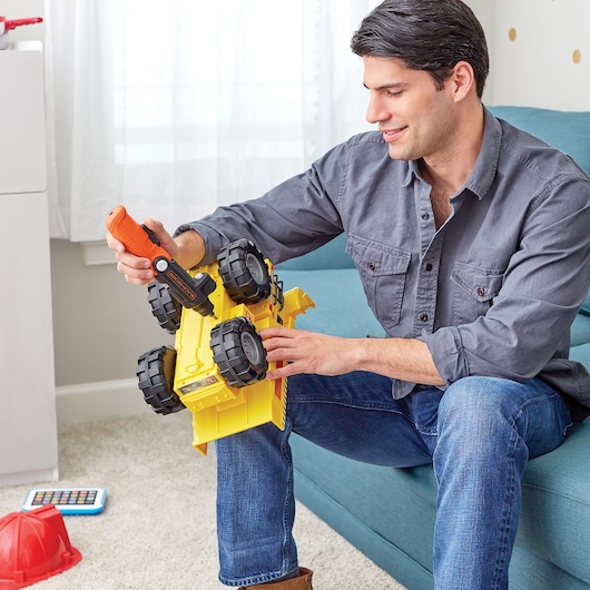Photo of BLACKDECKER BDCSFL20A98 orange cordless screwdriver used on yellow toy truck in living room.