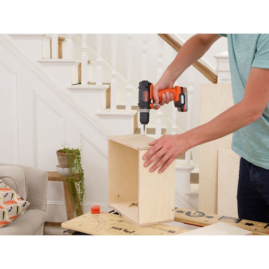 BLACKDECKER BDDD12 cordless drill used to assemble wooden box indoors.