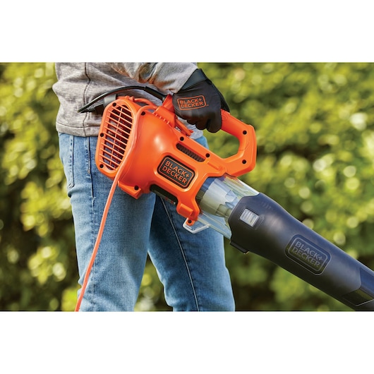 BLACKDECKER BEBL185 orange and black electric leaf blower held by person outdoors.