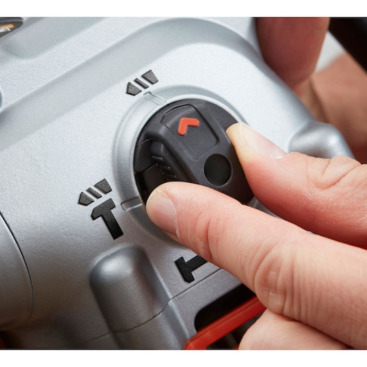 Close-up photo of a hand adjusting the BLACKDECKER BEHS03K rotary switch on a power tool housing.