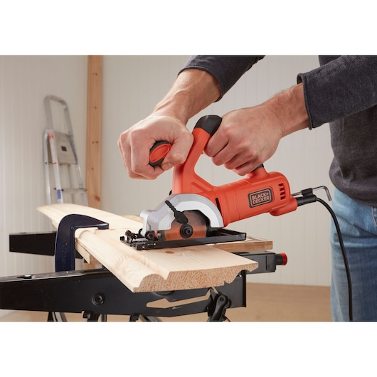 BLACKDECKER BES510K compact saw cutting wood, side angle, woodworking setup visible.