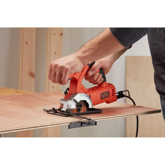 Photo of BLACKDECKER BES510K compact circular saw cutting plywood sheet, tool held by person.