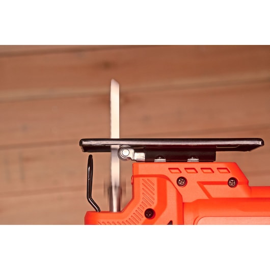 Photo of BLACK+DECKER BES603 jigsaw side view, showing orange body, metal shoe, and blade.