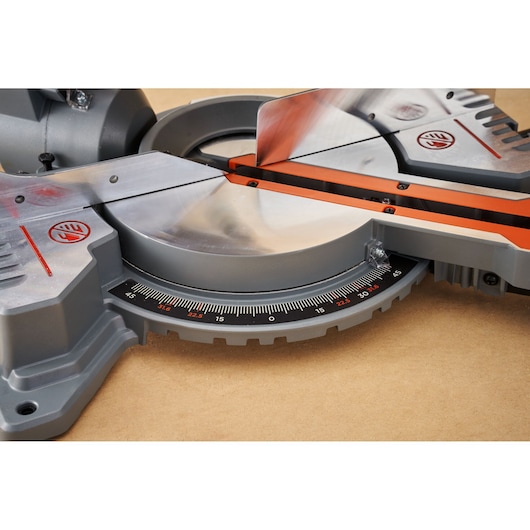 BLACKDECKER BES701 miter saw close-up showing silver blade, orange safety guard, and angle gauge, front angle.