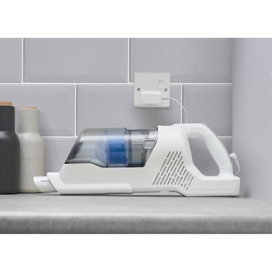 BLACKDECKER BHFEA420J cordless handheld vacuum in white and blue charging on kitchen counter, side view.