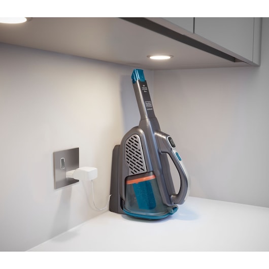 BLACKDECKER BHHV520BF cordless handheld vacuum on charging dock, side angle, with blue and gray design.