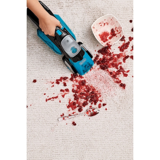 BLACK+DECKER BHSB320JP carpet cleaner cleaning red spill from white carpet, top view.