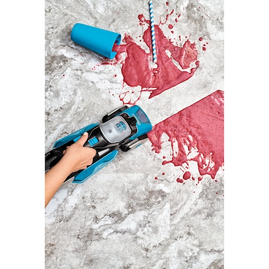 BLACK+DECKER BHSB320JP wet dry vacuum cleaning spilled red smoothie on tile floor, top view.