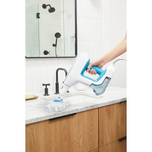 BLACKDECKER BHSM15FX08 steam cleaner with blue accents used on bathroom countertop.