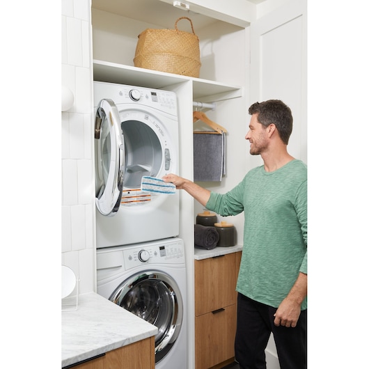 BLACKDECKER BHSM15FX08 steam mop pad held by person in laundry room near washing machine.