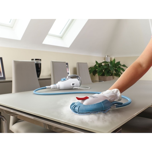 BLACKDECKER BHSM1615DAM steam cleaner in use on tabletop, blue and white handheld device.