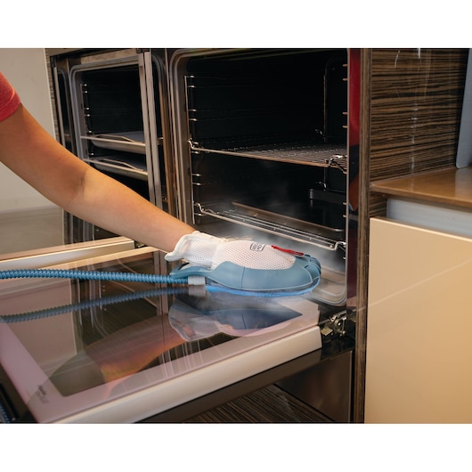Photo of BLACKDECKER BHSM1615DAM steam cleaning glove cleaning oven door interior.