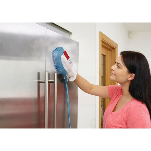 Photo of BLACKDECKER steam cleaning glove BHSM1615DAM in use on stainless steel refrigerator door.