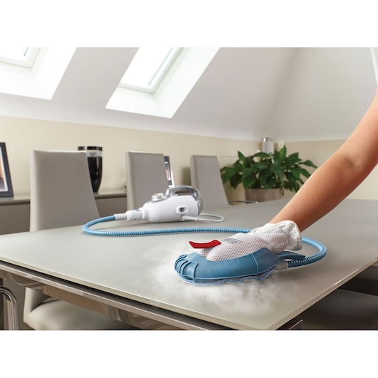 BLACKDECKER BHSM1615DSG steam cleaning glove cleaning a table, blue steam hose, modern dining room.