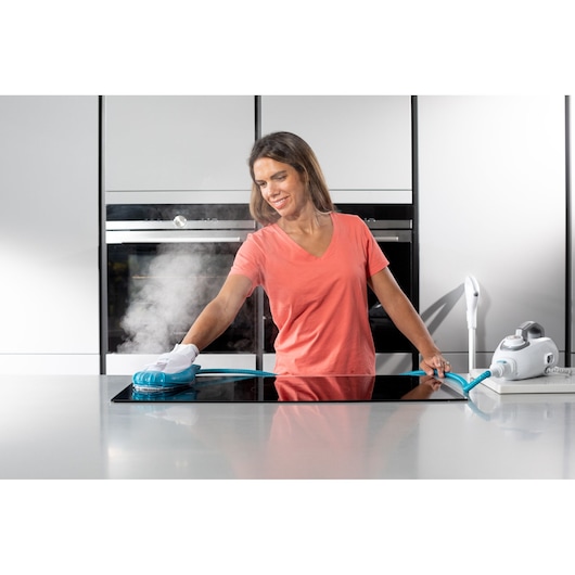 Photo of BLACKDECKER BHSM1615DSG steam cleaner being used to clean a kitchen stovetop, white appliance visible.