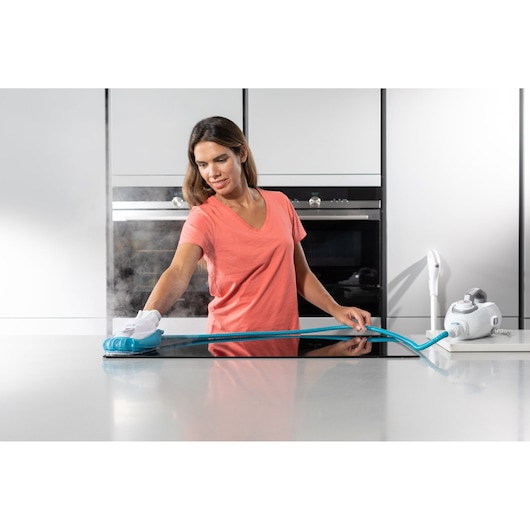 BLACKDECKER BHSM1615DSG steam cleaner with blue hose, cleaning a kitchen countertop, shown in use.