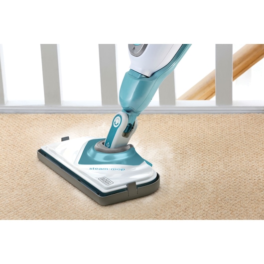 BLACK+DECKER BHSM168DSM steam mop cleaning beige carpet, close-up angle.