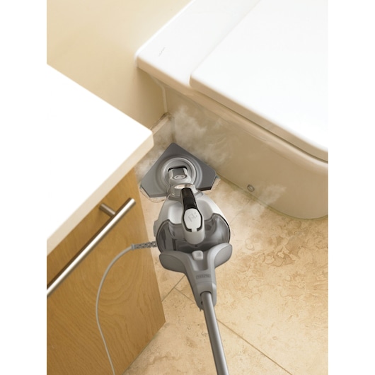 BLACKDECKER BHSM168D steam mop cleaning tile floor in bathroom corner, top-down angle.