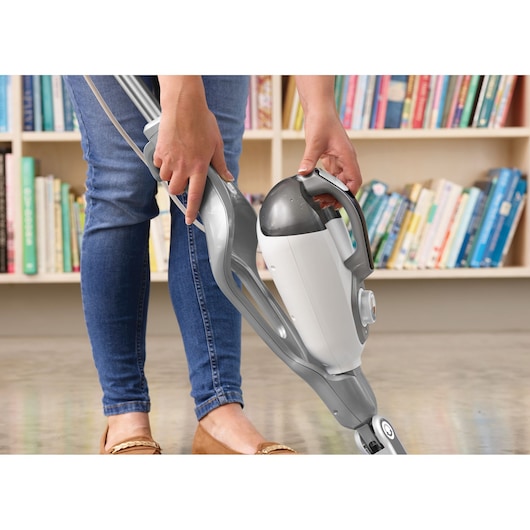 BLACKDECKER BHSM168D steam mop with detachable handheld unit, gray and white, shown in use indoors.