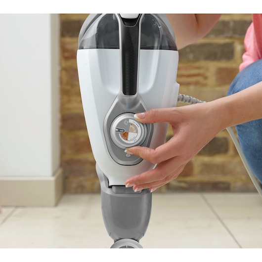 BLACKDECKER BHSM168D steam mop close-up, hand adjusting control dial, white and grey design.