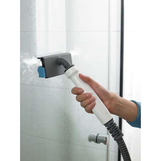 BLACKDECKER BHSM168U steam cleaner handheld attachment cleaning a glass shower door.