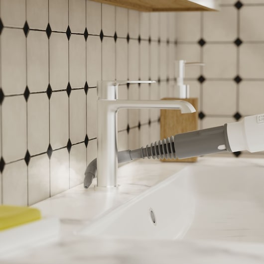 BLACKDECKER BHSMP2314 handheld steam cleaner nozzle cleaning around a bathroom faucet on a white sink.