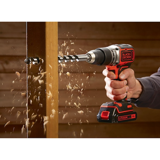 BLACK+DECKER BL188E2K cordless drill in use drilling wood, red and black, 18V Lithium battery.