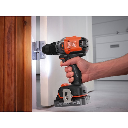 BLACKDECKER BLD683D1 cordless drill in use on door hinge, close-up view.