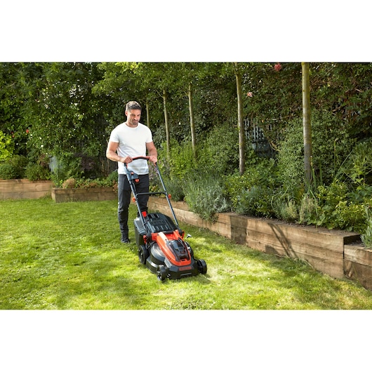 Photo of BLACKDECKER CLM3820L1 lawn mower in use on grass in a garden.
