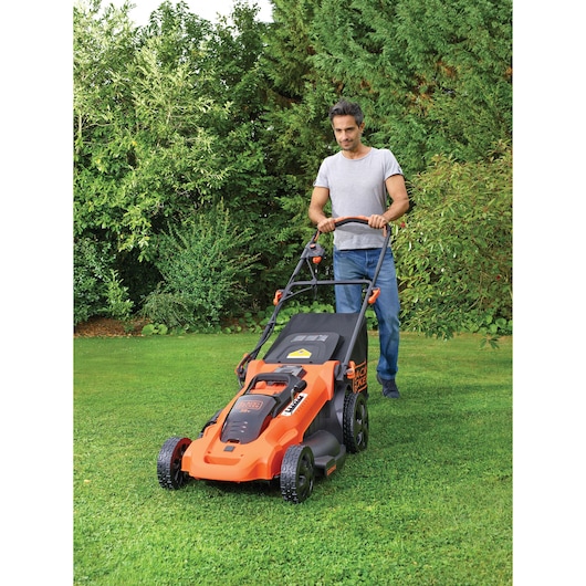 Photo of BLACKDECKER CLMA4820L2 lawn mower in use outdoors on a green lawn.