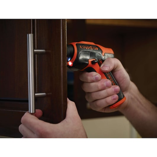BLACKDECKER CS36BST cordless screwdriver in use, tightening a cabinet handle, close-up view.