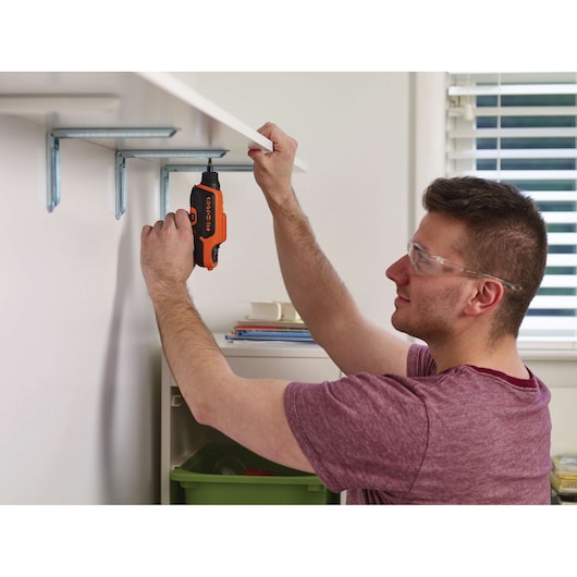 BLACKDECKER CS36BST cordless screwdriver used to install a shelf bracket in a home setting.